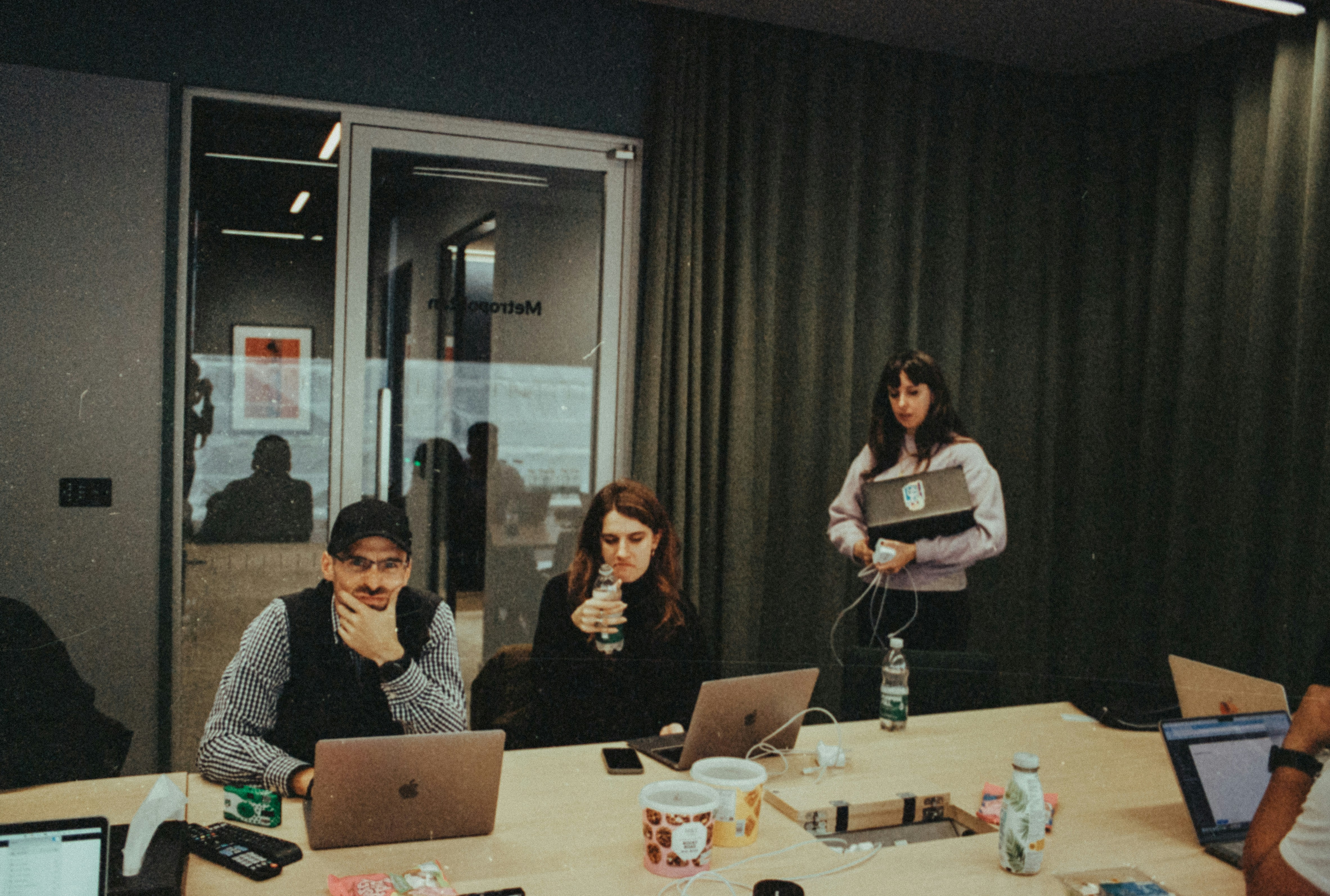 Group of people collaborating around laptops at a table