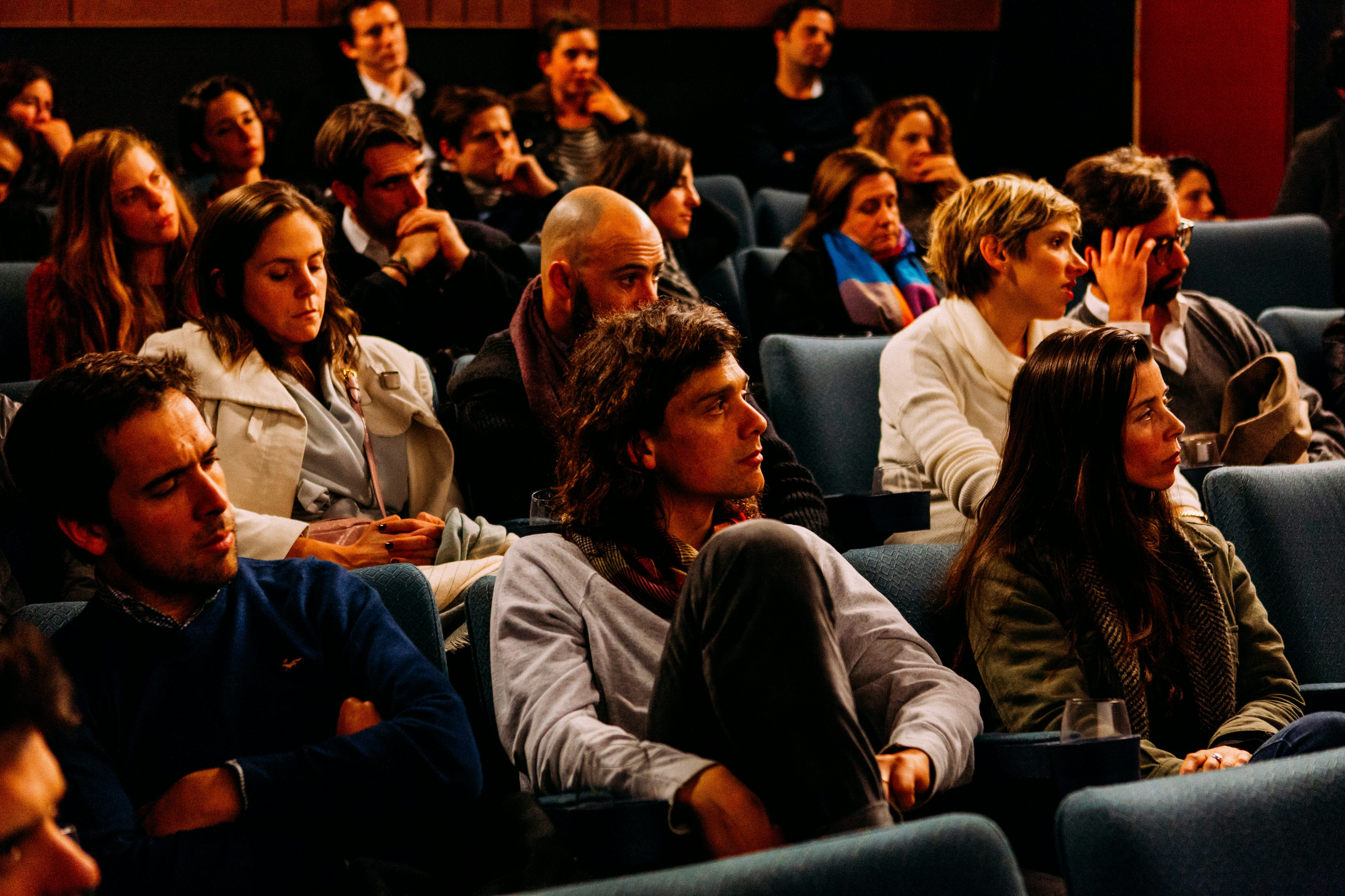 Group of people watching a presentation in a room, audience facing a screen