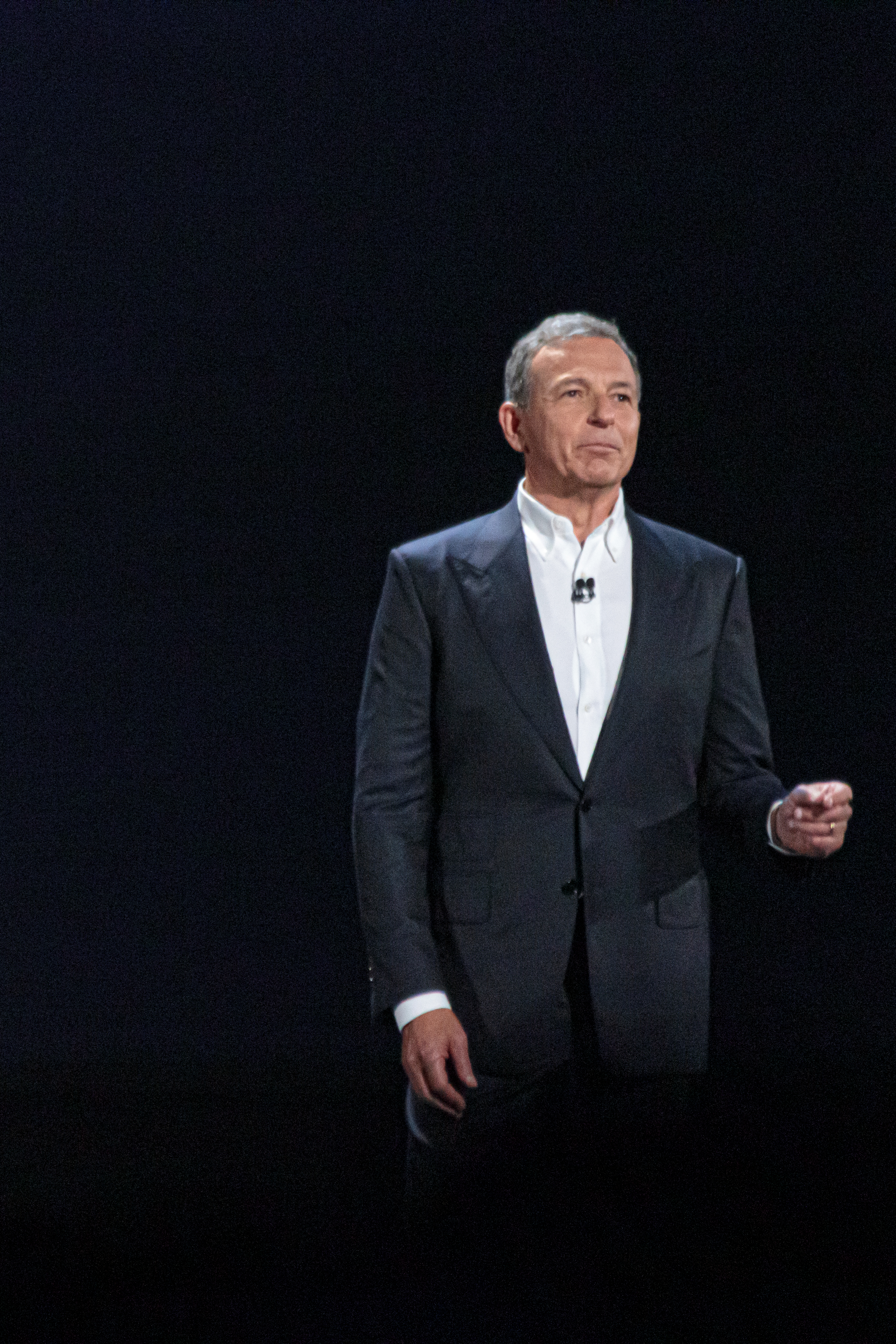 Disney CEO Bob Iger presenting on stage in business attire