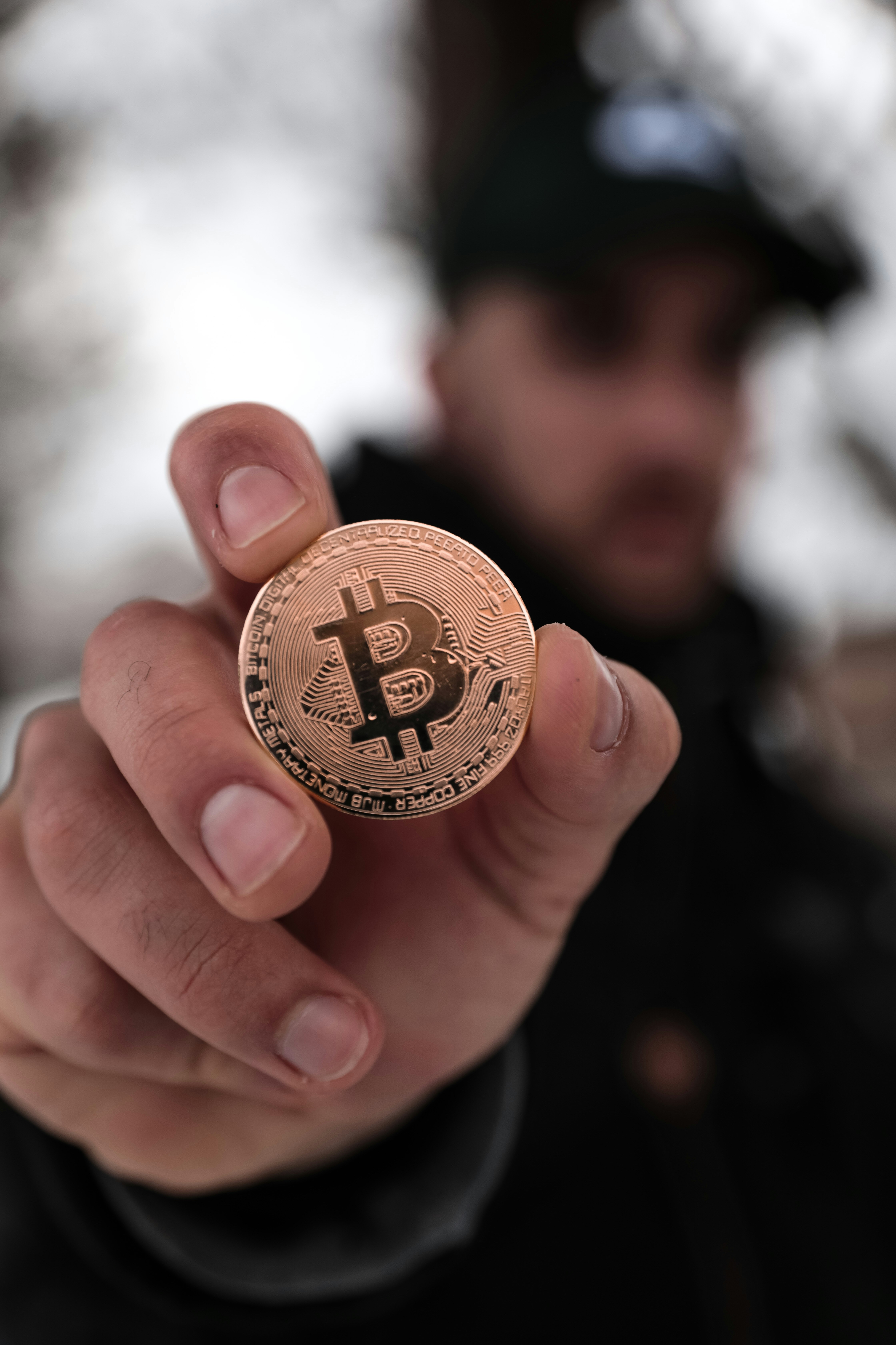 Person holding a Bitcoin coin, representing the cryptocurrency at the heart of the Killing Satoshi story