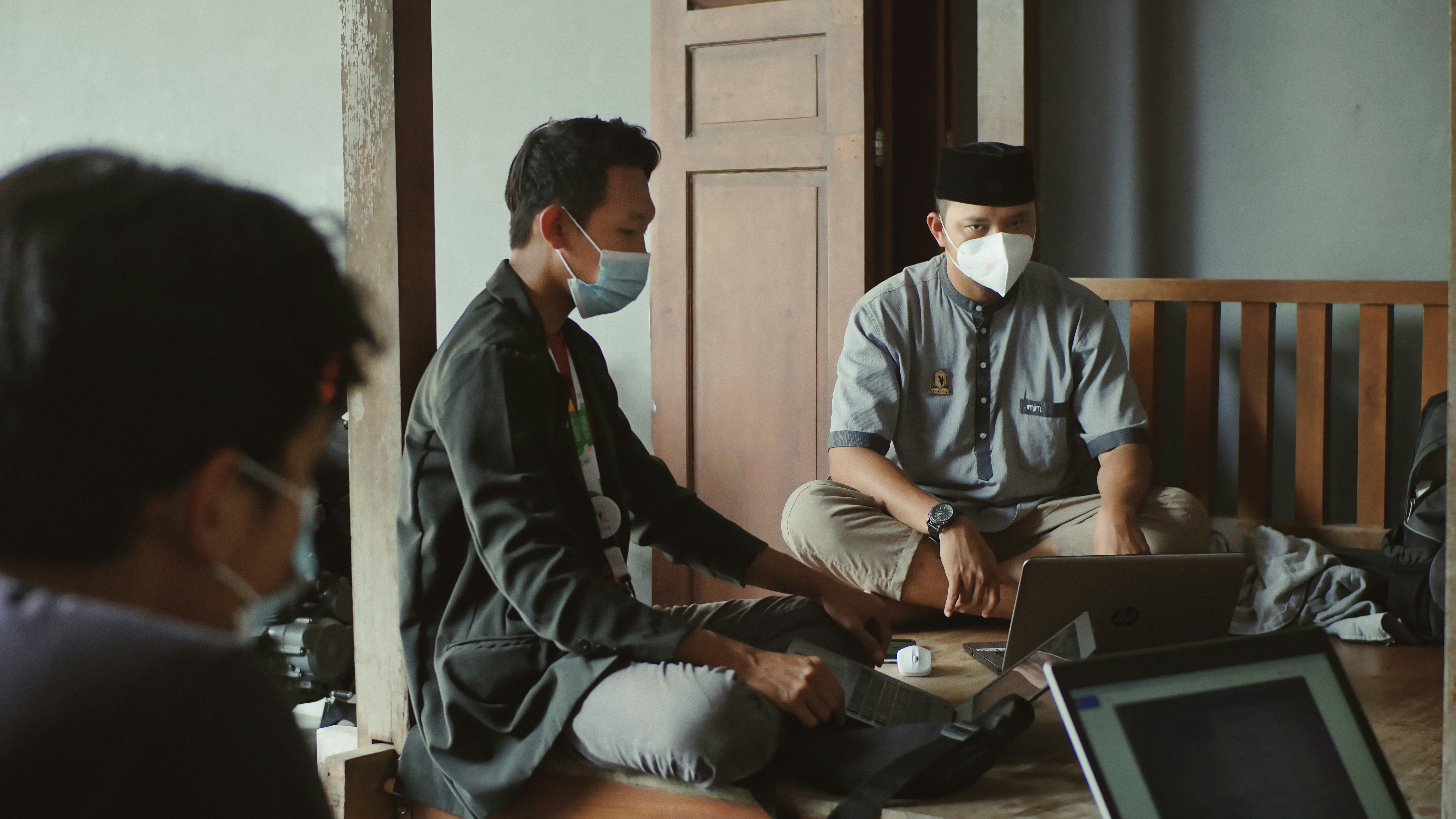 Indonesian filmmakers collaborating with laptops during a production meeting